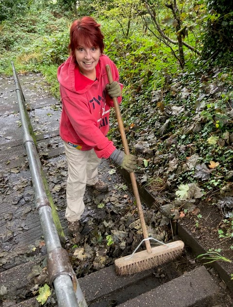 TQ6 Volunteer sweeping leaves from path