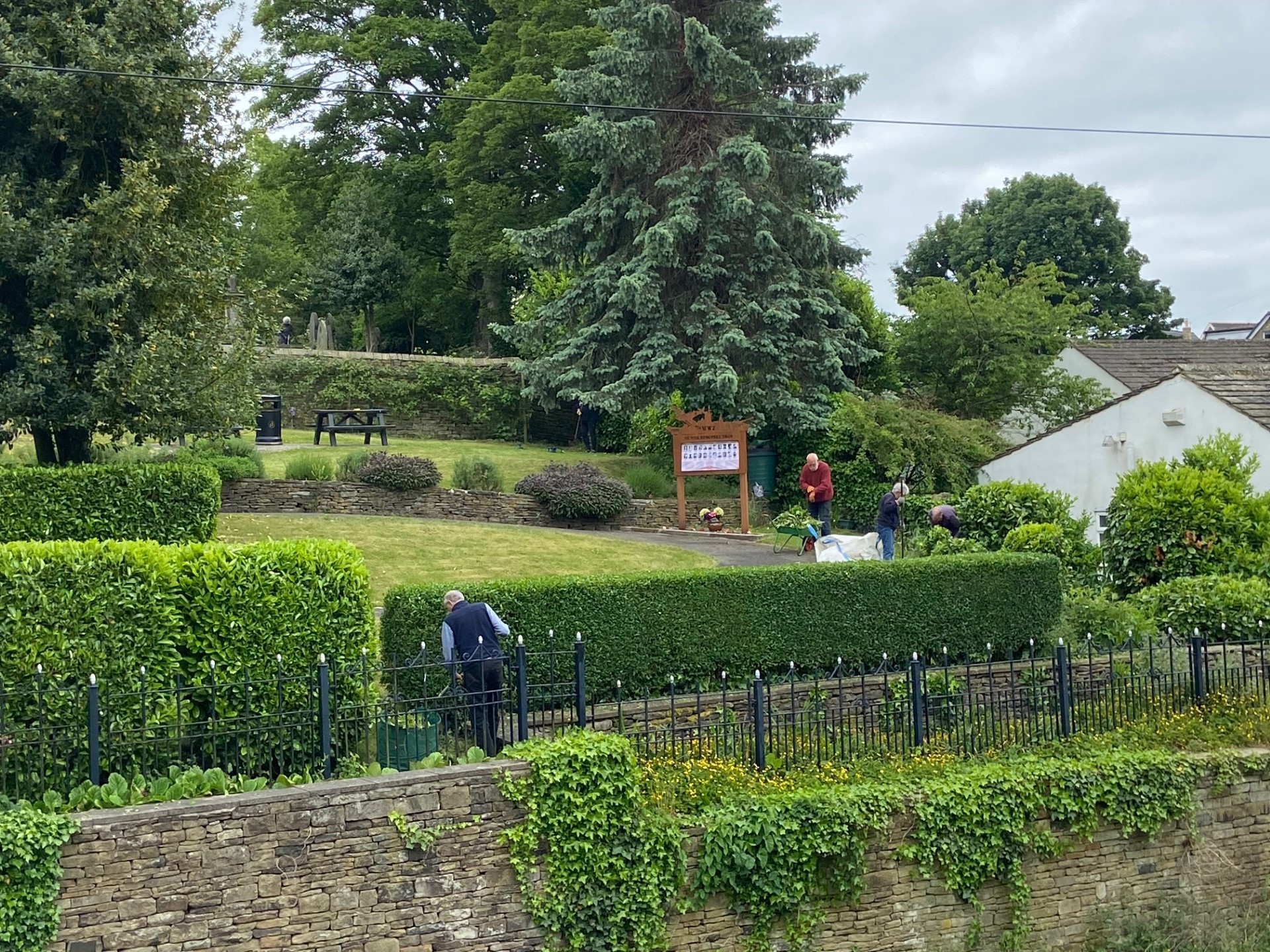 The Memorial Gardens being tidied up by volunteers - trimming all the shrubs, cutting grass and deadheading plants.