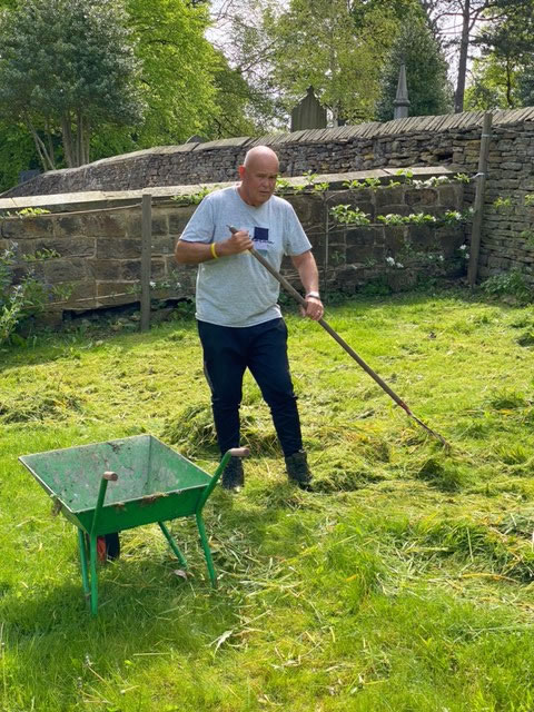 Volunteer scarifying to remove the moss and dead grass embedded in the all the grassed areas.