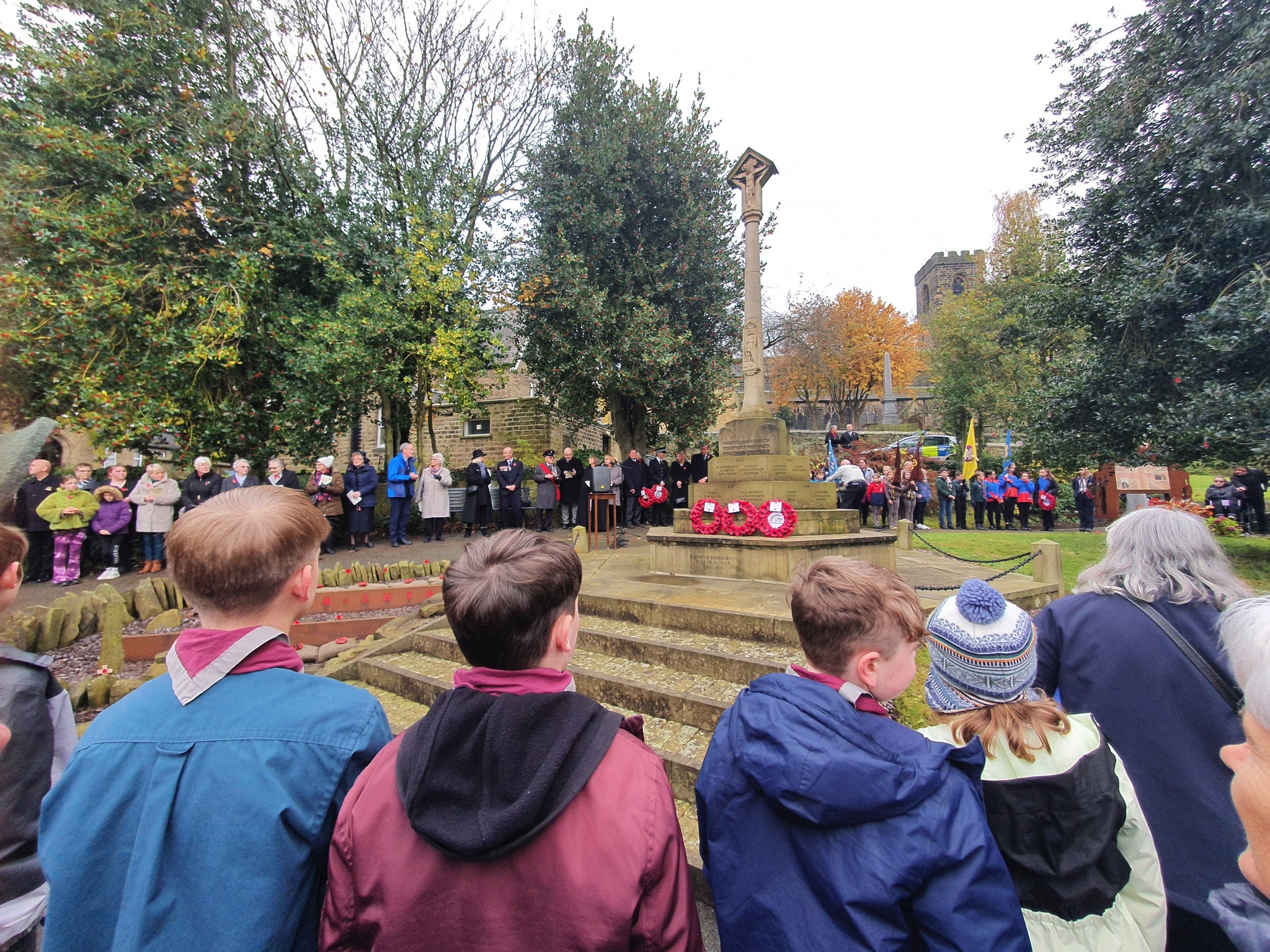 People gathered around the monument in the Memorial Garden for an act of Remembrance