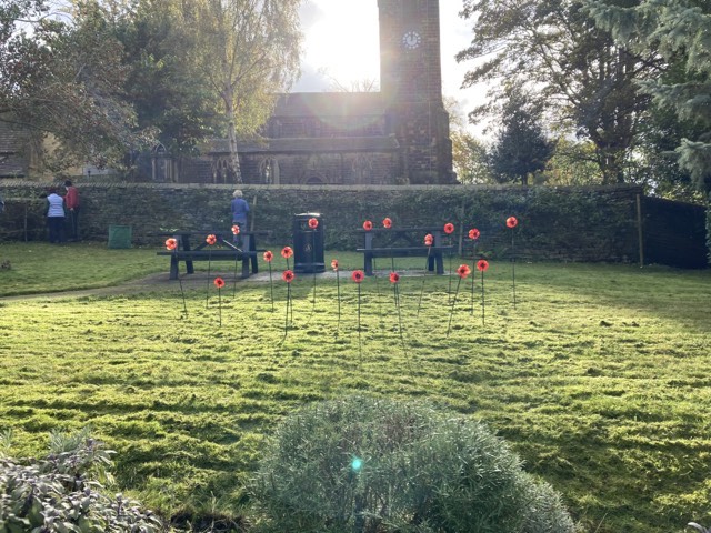 Poppy sculptures in the foreground of the Memorial Gardens with the Church in the background