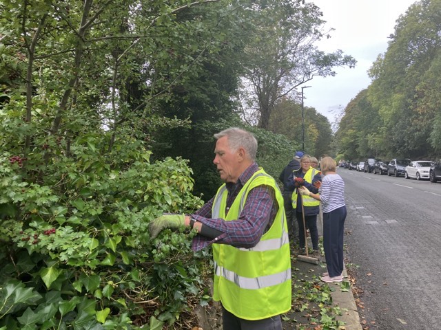 Volunteers clearing foliage to keep paths clear for pedestrians